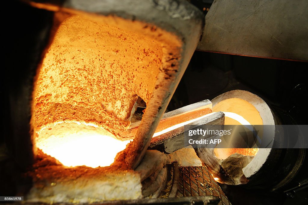 A golden bar is melted into a furnace  o