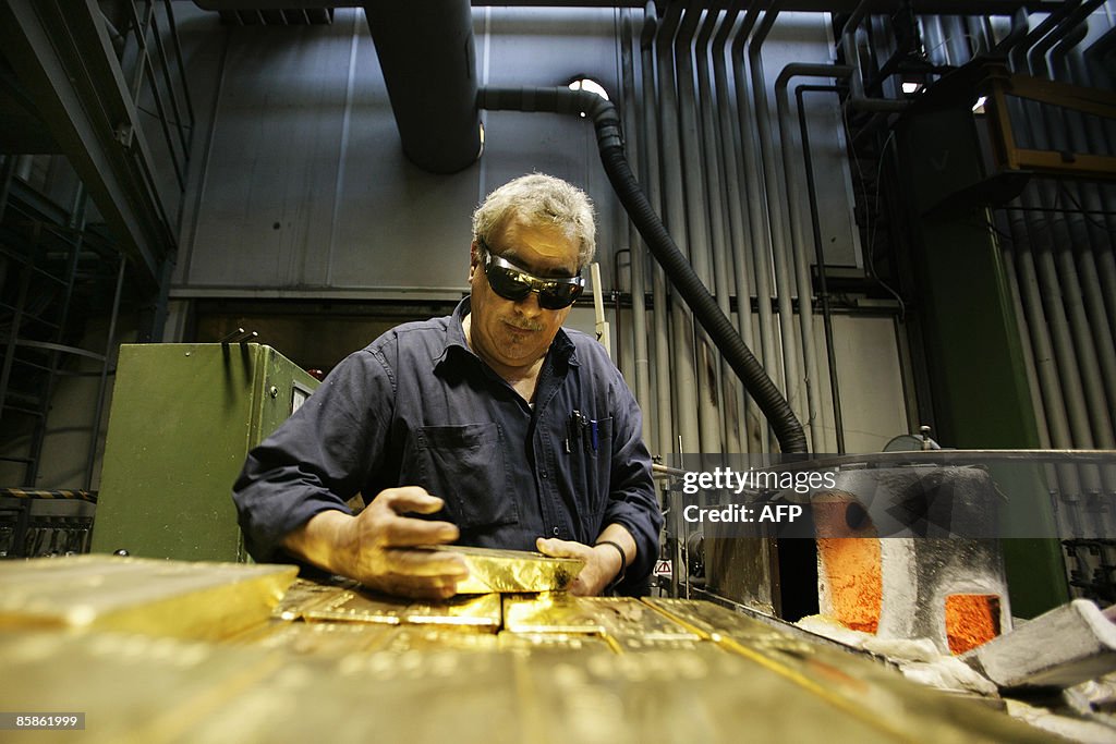 An employee holds a 12.5 kg golden bar