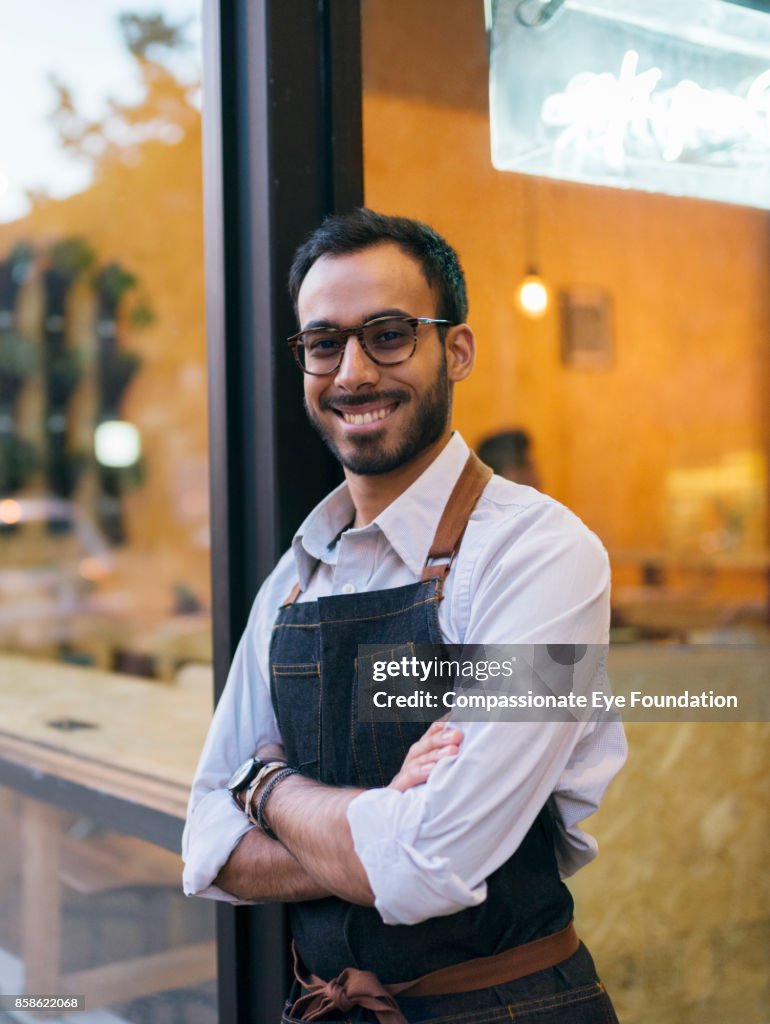 Portrait of business owner standing outside cafe