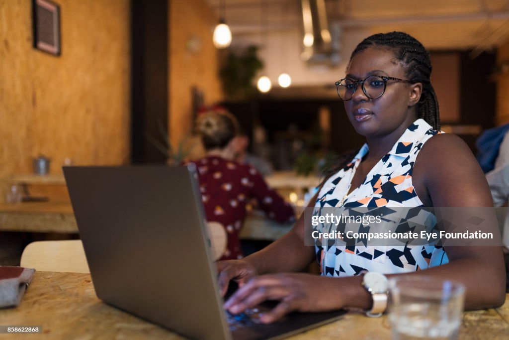 Businesswoman using laptop in cafe