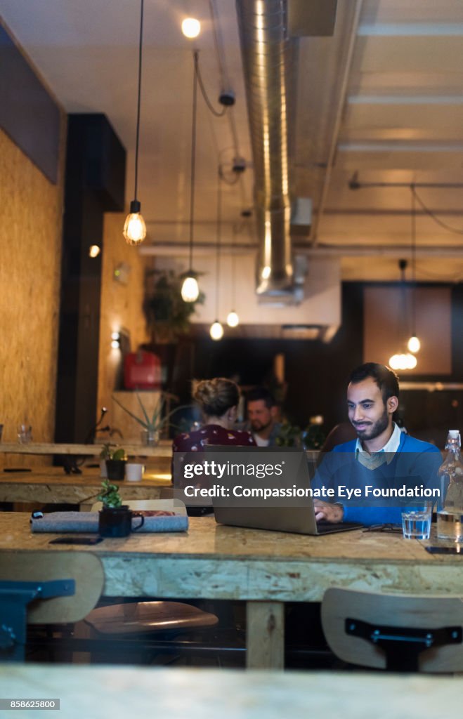 Businessman using laptop in cafe