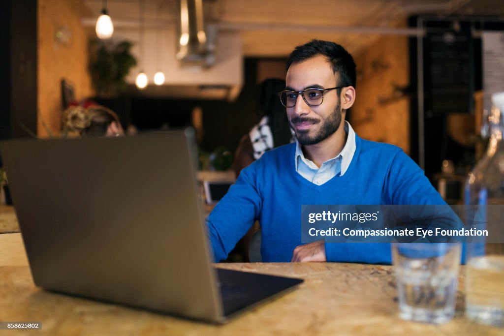 Businessman using laptop in cafe