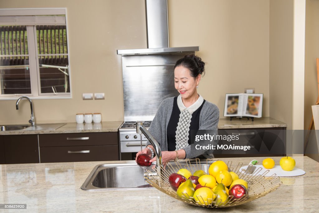 Fashionable mature woman in the modern kitchen