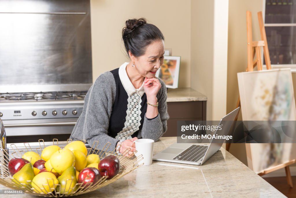 Fashionable mature woman using laptop