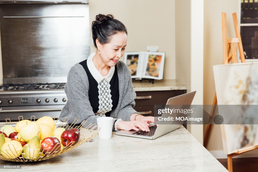 Fashionable mature woman using laptop