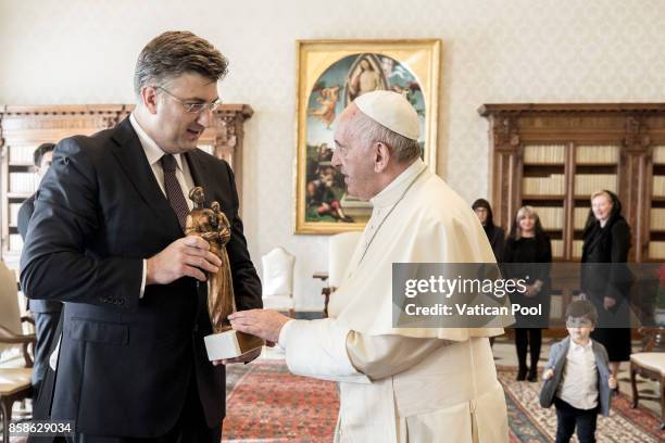 Pope Francis exchanges gifts with Croatia's Prime Minister Andrej Plenkovic and his family during an audience at the Apostolic Palace on October 7,...