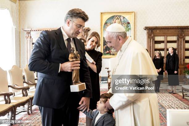 Pope Francis exchanges gifts with Croatia's Prime Minister Andrej Plenkovic and his family during an audience at the Apostolic Palace on October 7,...