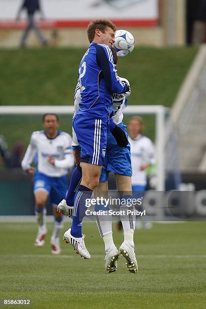 Jimmy Conrad of the Kansas City Wizards jumps over Cam Weaver of the San Jose Earthquakes for a head ball at Community America Ballpark in Kansas...