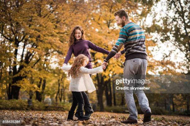 happy ginger family playing ring-around-the-rosy during autumn day at the park. - ring around the rosy stock pictures, royalty-free photos & images