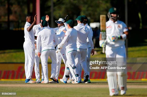 South Africa's bowler Kagiso Rabada is congratulated by teammates after his dismissal of Bangladesh's batsman Sabbir Rahman during the second day of...