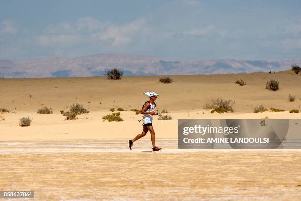 Participant runs during the Ultra Mirage El Djerid marathon in the desert near the southwestern Tunisian city of Tozeur on October 7, 2017. - The...