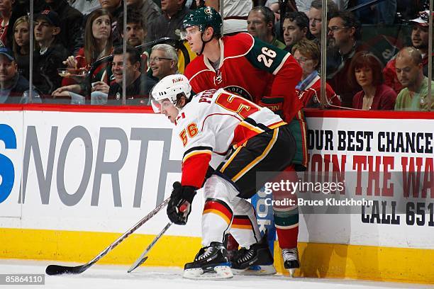 Matt Pelech of the Calgary Flames and Kurtis Foster of the Minnesota Wild battle for position during the game at the Xcel Energy Center on April 3,...