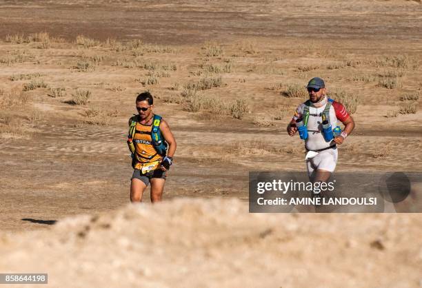 Participants run during the Ultra Mirage El Djerid marathon in the desert near the southwestern Tunisian city of Tozeur on October 7, 2017. - The...