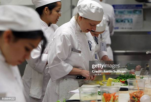 Culinary student Joanna Terry cuts vegetables during a butchery class at the Le Cordon Bleu program at California Culinary Academy April 8, 2009 in...