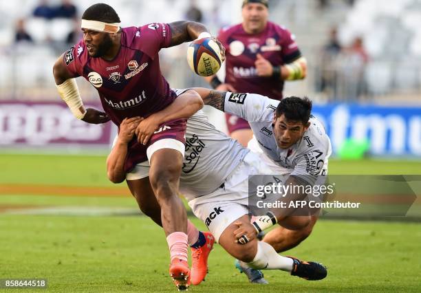 Bordeaux-Begles' Fijian centre Apisai Naqalevu runs with the ball as he tackled by Toulon's players during the French Top 14 rugby union match...