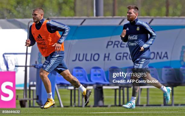 Argentina's farwards Lionel Messi and Mauro Icardi run during a training session in Ezeiza, Buenos Aires on October 7, 2017 ahead of a 2018 FIFA...