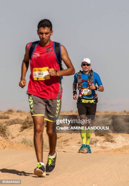 Participants run during the Ultra Mirage El Djerid marathon in the desert near the southwestern Tunisian city of Tozeur on October 7, 2017. - The...