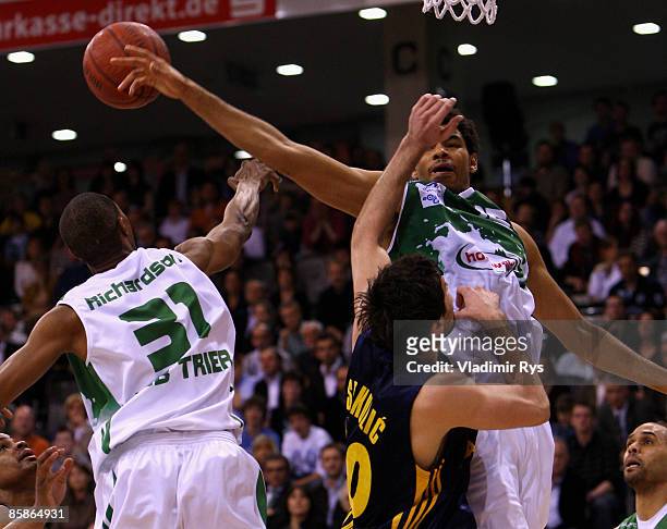 Christopher Copeland and Norman Richardson from Trier and Blagota Sekulic of Berlin jump for a rebound during the Bundesliga game between TBB Trier...