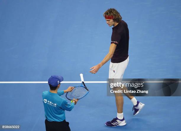 Ball-kid gives back his broken racqet to Alexander Zverev of Germany during his Men's singles semifinal match against Nick Kyrgios of Australia on...