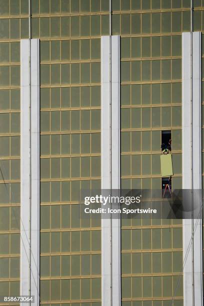 Workers board up one of the windows at Mandalay Bay Resort and Casino in Las Vegas on October 6 where a gunman fired during a mass shooting that...