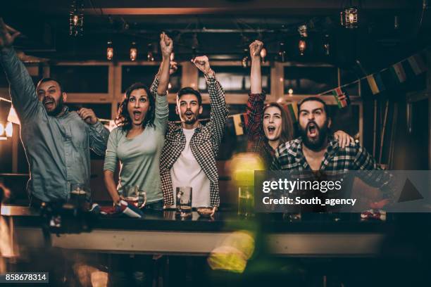 friends in bar watching game - celebration people watching stock pictures, royalty-free photos & images