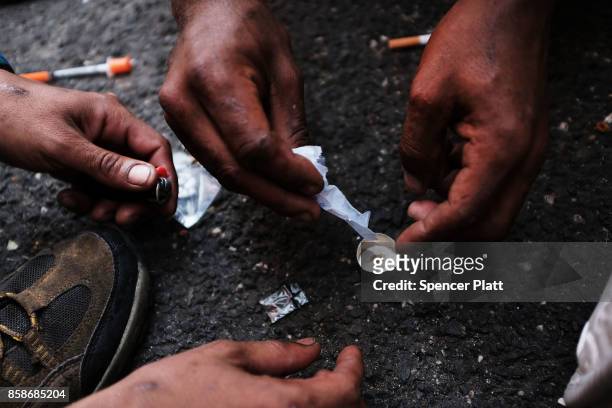 Heroin users prepare to shoot up on the street in a South Bronx neighborhood which has the highest rate of heroin-involved overdose deaths in the...