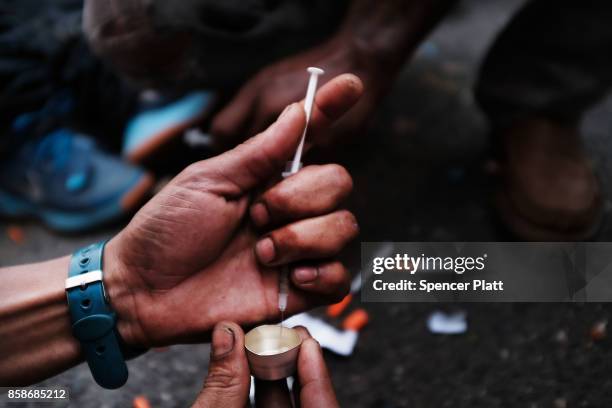 Heroin user prepares to shoot up on the street in a South Bronx neighborhood which has the highest rate of heroin-involved overdose deaths in the...