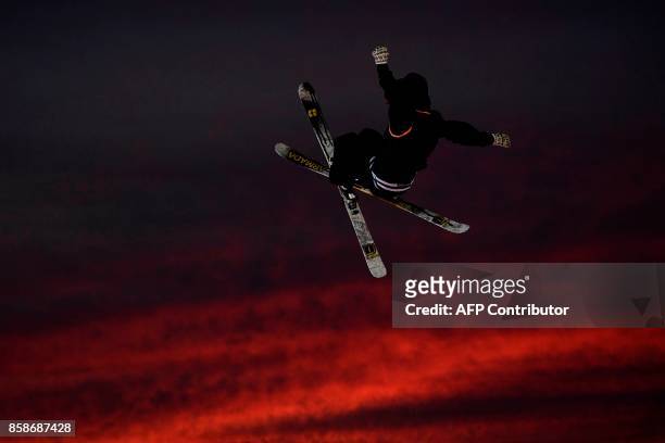 Freestyle skier performs at sunset during the Sosh Big Air, a competition of freestyle skiers and snowboarders, in Annecy on October 7, 2017 as part...