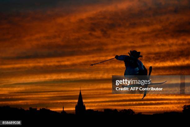 Freestyle skier performs at sunset during the Sosh Big Air, a competition of freestyle skiers and snowboarders, in Annecy on October 7, 2017 as part...