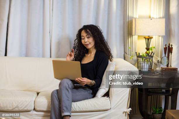 a woman using a laptop - tdub_video stock pictures, royalty-free photos & images