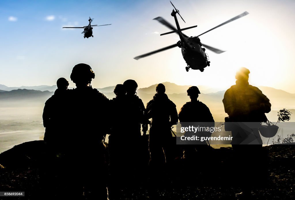 Silhouetten von Soldaten während der Militärmission in der Abenddämmerung