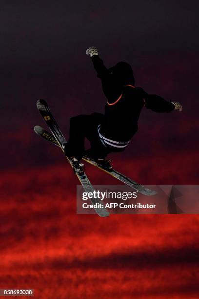 Freestyle skier performs at sunset during the Sosh Big Air, a competition of freestyle skiers and snowboarders, in Annecy on October 7, 2017 as part...