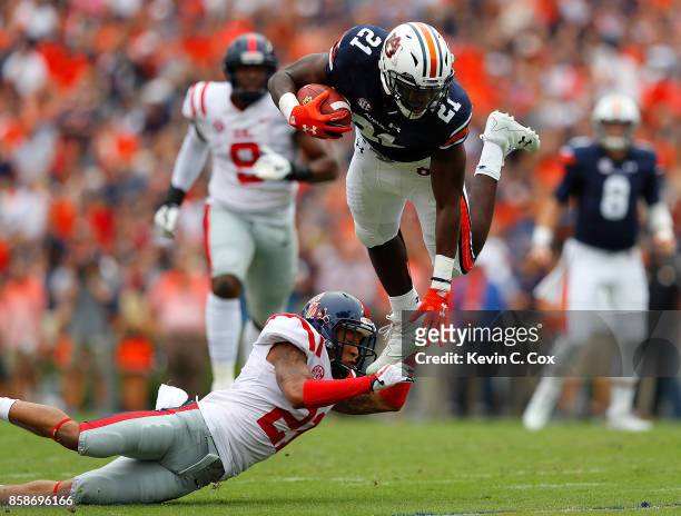 Kerryon Johnson of the Auburn Tigers is tripped up as he leaps over Javien Hamilton of the Mississippi Rebels at Jordan Hare Stadium on October 7,...