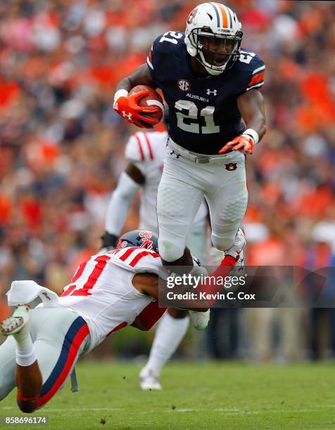 Kerryon Johnson of the Auburn Tigers is tripped up as he leaps over Javien Hamilton of the Mississippi Rebels at Jordan Hare Stadium on October 7,...