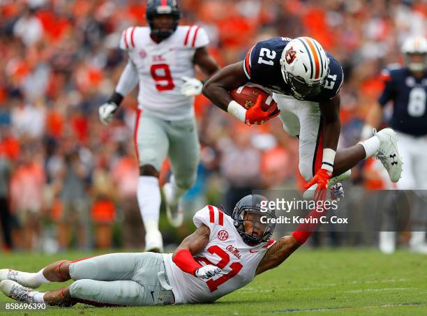 Kerryon Johnson of the Auburn Tigers is tripped up as he leaps over Javien Hamilton of the Mississippi Rebels at Jordan Hare Stadium on October 7,...