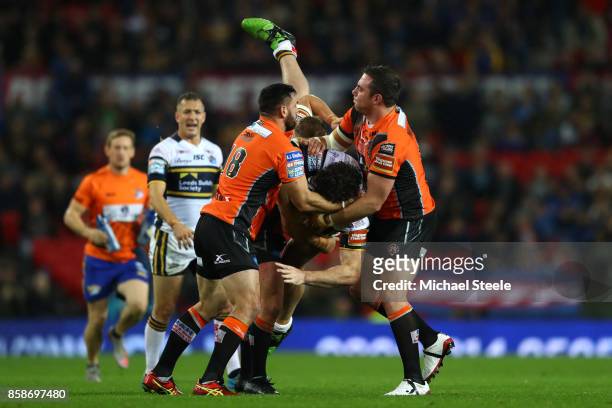 Mitch Garbutt of Leeds Rhinos is tackled by Matthew Cook and Grant Millington of Castleford Tigers during the Betfred Super League Grand Final match...