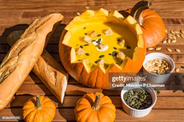 pumpkin soup in shell served with bread and roasted pumpkin seeds - scodella per zuppa foto e immagini stock
