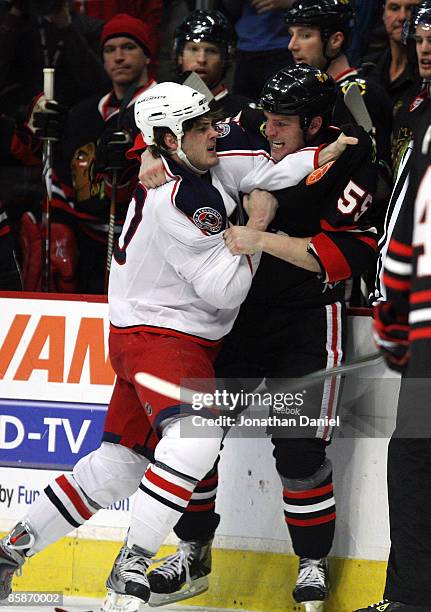 Ben Eager of the Chicago Blackhawks and Jared Boll of the Columbus Blue Jackets fight in front of the Blackhawk bench on April 8, 2009 at the United...