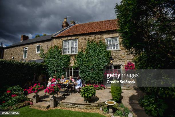 donne che pranzano nel patio di un cottage - casetta di campagna foto e immagini stock