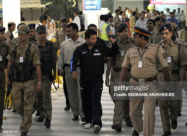 Indian cricketer Sachin Tendulkar gestures to supporters as he walks out of the city airport after arriving from New Zealand in Mumbai late April 8,...