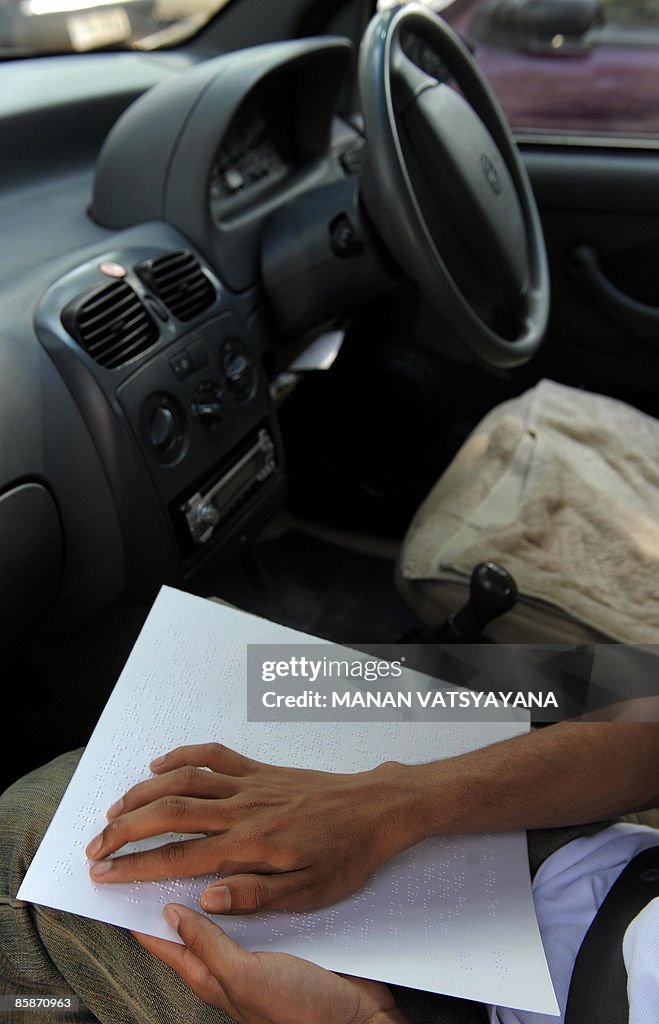A visually disabled Indian boy reads the
