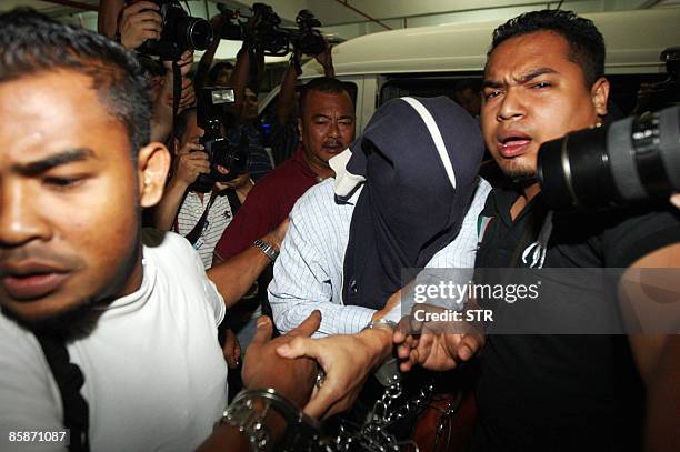 Malaysian security officers carry away one of the policemen with covered face found guilty in a Mongolian model girl murder case, at Shah Alam high...