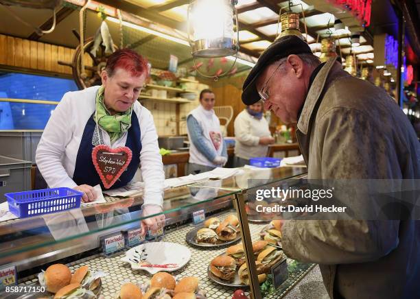 Stephan Weil , German Social Democrat and governor of the state of Lower Saxony, talks to a food vendor at a fun fair while campaigning in the Lower...