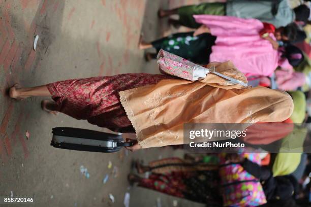 Rohingya people, fled from ongoing military operation in Myanmar Rakhain state, walks along the road at Shah Pori Island to go to refugee camp in...