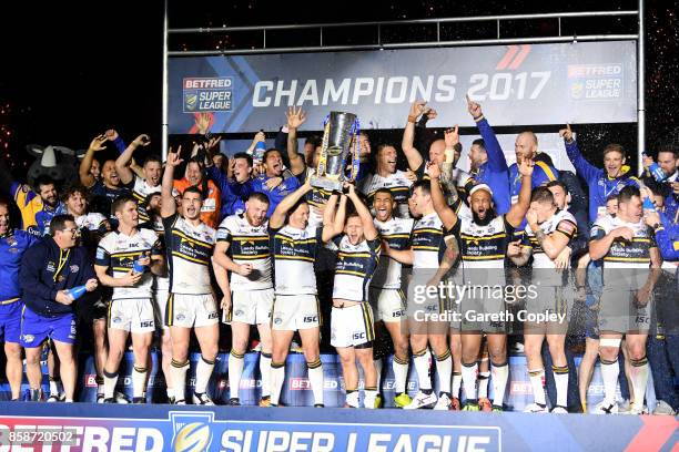 Danny McGuire and Rob Burrow of Leeds Rhinos lift the trophy with their team-mates at the end of the Betfred Super League Grand Final match between...