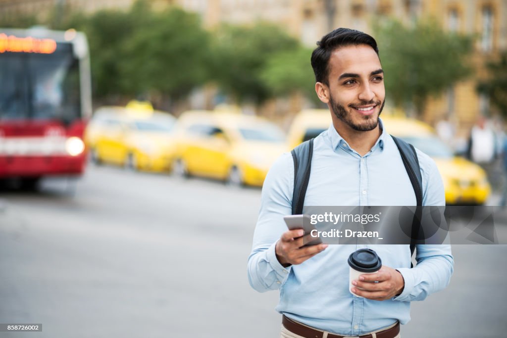 Latino Mann mit mobile app Crowdsourcing-Taxi rufen