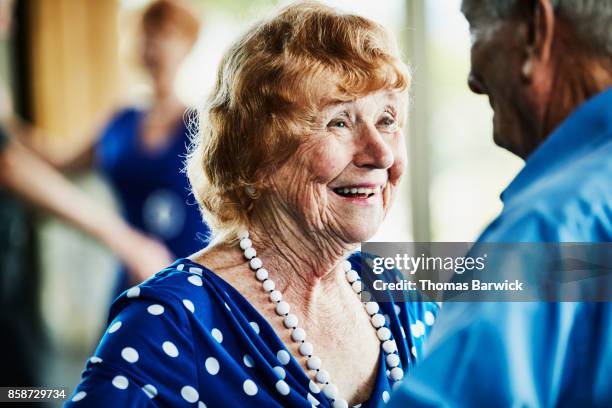 smiling senior woman looking at husband while dancing in ballroom - balzaal stockfoto's en -beelden