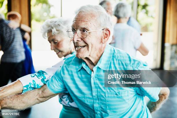 senior man dancing with partner in community center - atividade imóvel imagens e fotografias de stock