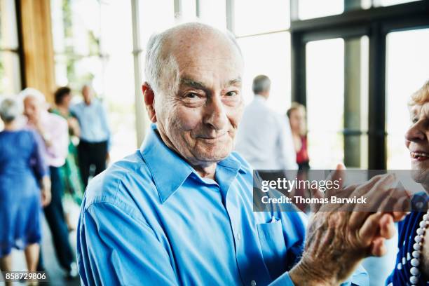 smiling senior man clapping after dancing with wife in ballroom - differential focus stock pictures, royalty-free photos & images