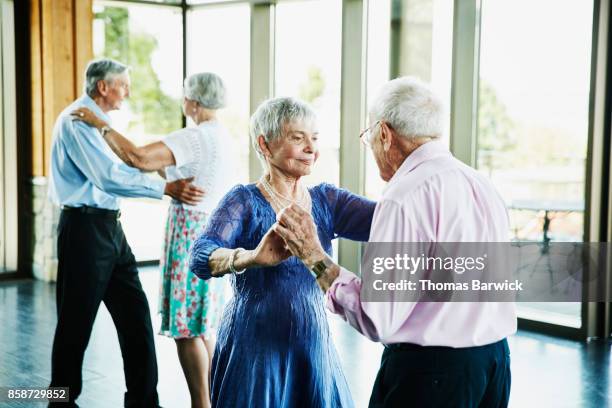 senior couple dancing together in community center - ballroom stockfoto's en -beelden